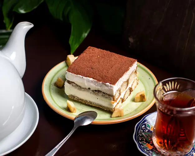 tiramisu-cake-with-cacao-powder-top-served-with-tea_140725-8829